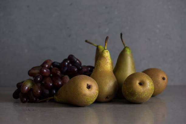 Autumn fruit still life with pears and grapes on the grey background