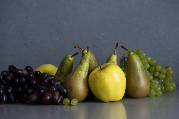 Autumn fruit still life with pears, apples and grapes on the grey background