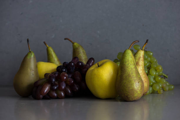 Autumn fruit still life with pears, apples and grapes on the grey background