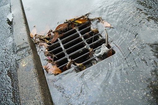Minor flooding around a partly blocked drain after a rainstorm. See also