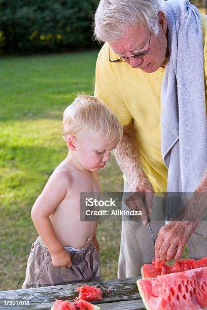 Grandpa Cortes En Sandía Watermelon Stomach Foto de stock y más banco de imágenes de Abuelo - Abuelo, Adulto, Adulto maduro