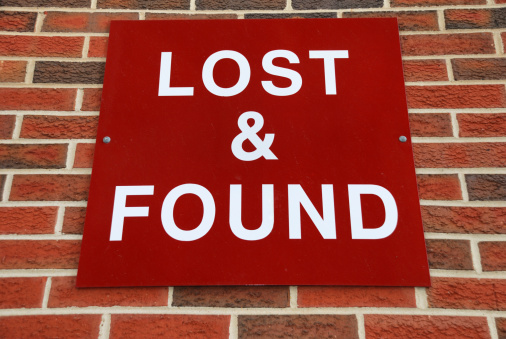 Red lost and found sign on brick wall