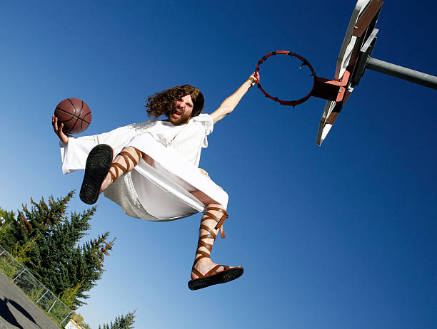 jesús slam dunking un pallone da pallacanestro - hanging basket foto e immagini stock