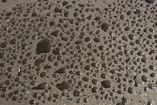A photo of some water droplets on some newly laid tarmac.  Dark background good for layering over photos as a filter.  Good texture.