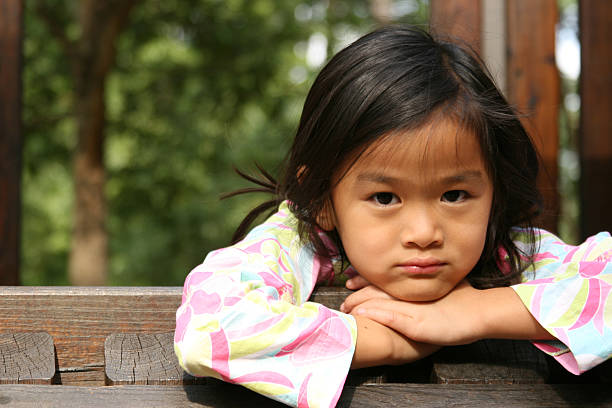 istock Chinese girl with head in hands 173018703