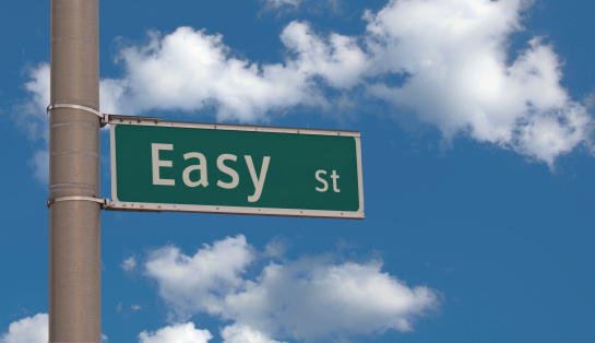 an actual road sign of Easy Street set against a blue cloudscape