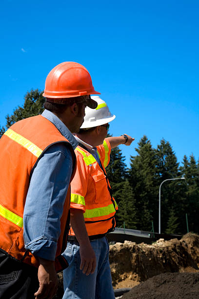 project manager si occupa di prevenzione dell'erosione del suolo'series'sicurezza casco arancione che indica - prevenzione dellerosione del suolo foto e immagini stock