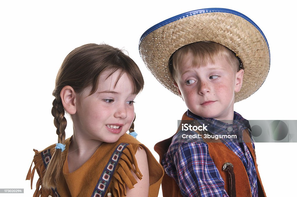 Children Dressed as a Cowboy and  Indian Two cute little children checking out each other's costumes.  One is a Native American Indian and one is a cowboy.For more Halloween Photos click here Child Stock Photo
