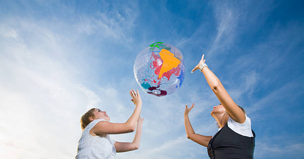 istock Two young ladies throwing up inflatable globe 173020523