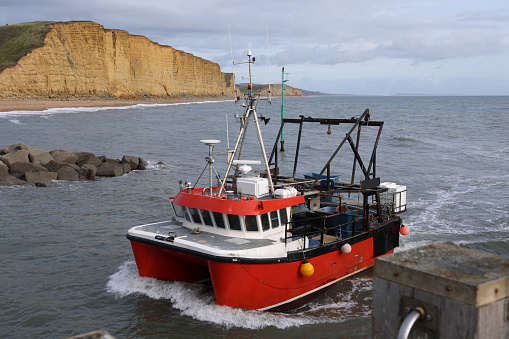 istock Fishing boat entering West Bay harbour 1730208286