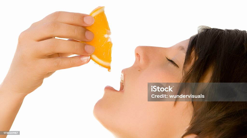 drop of freshness young beutiful girl enjoys a drop of orange juice. isolated. Adult Stock Photo