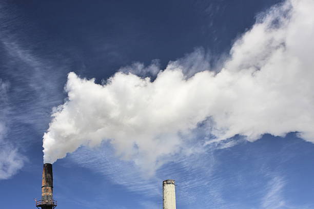 Factory Smokestack Emits Pollution Smoke Factory smokestack emits thick white smoke as cirrus clouds pass overhead. air quality stock pictures, royalty-free photos & images