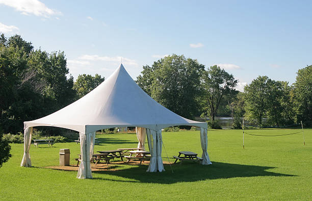 kleine marquee-zelt mit picknick-tische in einem park - tenths stock-fotos und bilder