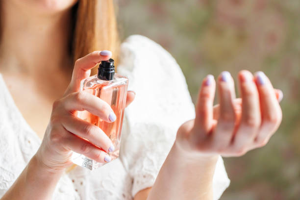 istock Beautiful young woman using perfume at home 1730216705