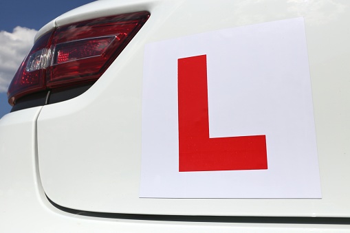 magnetic British L-plate affixed to the back of a white car