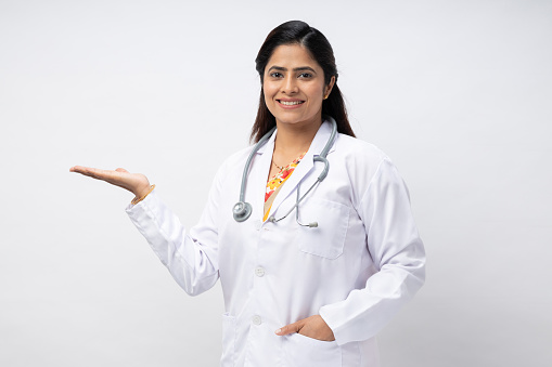 happy doctor pointing with finger on white background