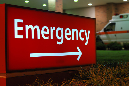Ambulance sitting behind ER sign