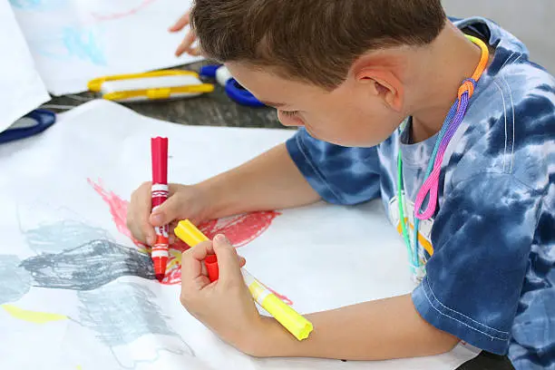 Photo of Boy coloring and hand-crafting a self-made kite