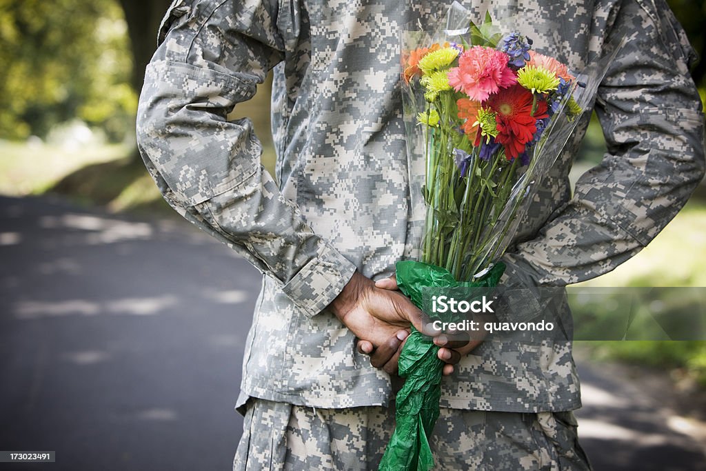 Soldado con un ramo de flores detrás de la espalda, espacio de copia - Foto de stock de Día de San Valentín - Festivo libre de derechos