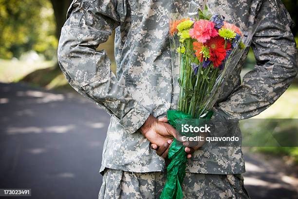 Photo libre de droit de Soldat Avec Bouquet De Fleurs Derrière Le Dos Espace De Copie banque d'images et plus d'images libres de droit de Armée