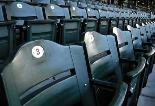 Looking down the line at seating at a baseball stadium.