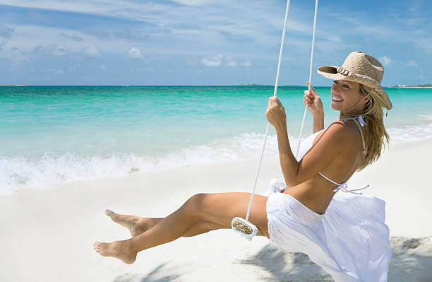 Young woman sunbathing and relaxing on chair in a Tropical white sand island beach
