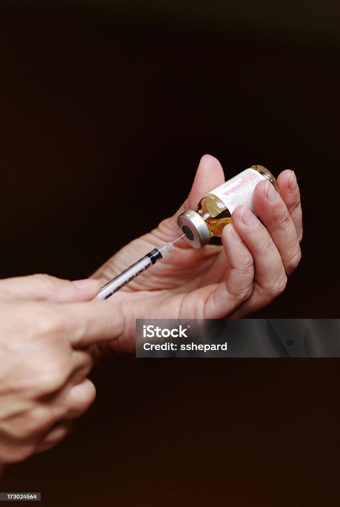 Filling syringe against dark background Womans hand filling syringe against dark background Cancer Drug Stock Photo