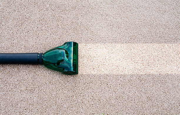 A vacuum cleaning a dirty carpet stock photo