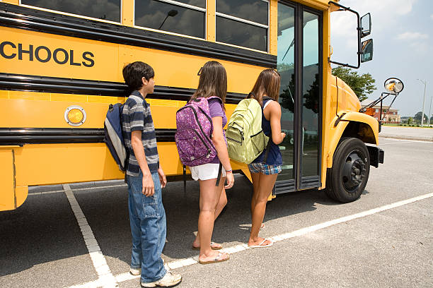 istock 3 kids waiting to get on the bus 173024812