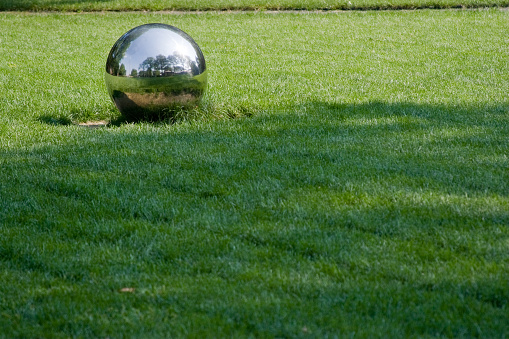 Steel ball on the green grass lawn