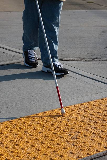 Accessible Sidewalk Edge Bumps at the edge of a crosswalk tell a blind cane user that he is about to step out into the street.All images in this series... blind persons cane stock pictures, royalty-free photos & images