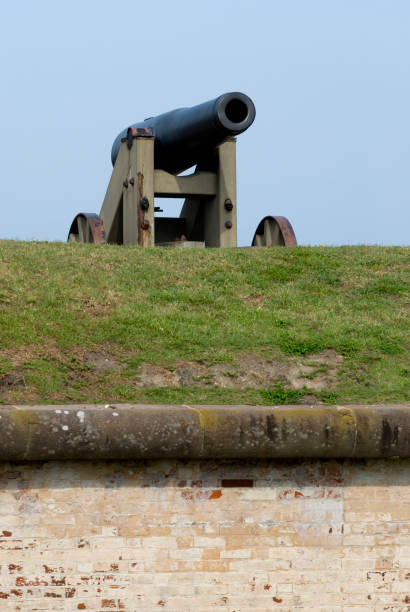 istock Cannon on Grass at Military Fort Vertical Over Brick Wall 173025431