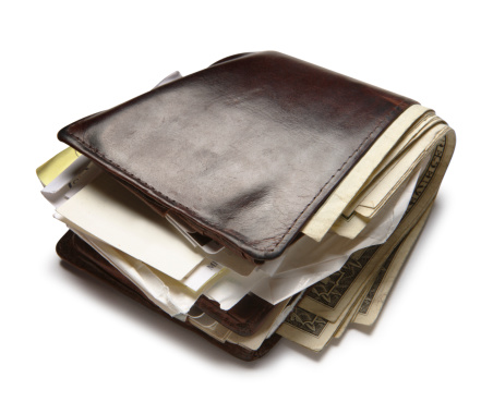 An old wallet stuffed with money and papers.