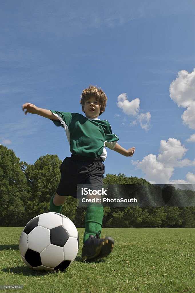 Niño gritando pelota de fútbol en verde - Foto de stock de Actividad libre de derechos