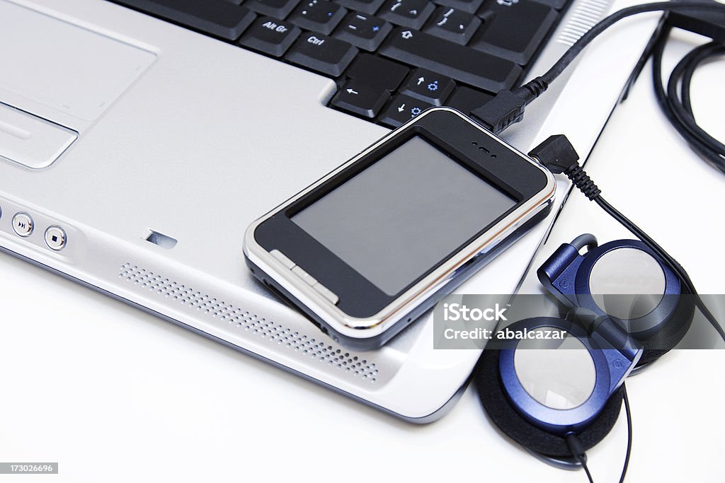 sharing music generic mp4 player with touchscreen connected to laptop and earphones Audio Electronics Stock Photo