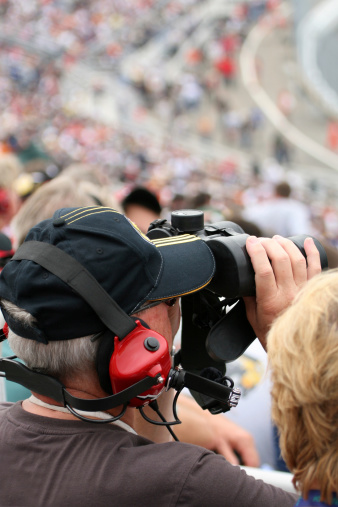 Man fan at racing event with binoculars