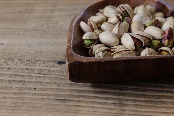 istock Pistachios on a heart shaped plate on a wooden table. 1730274998