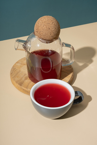 Cup and glass teapot with cranberry tea minimalist still life.