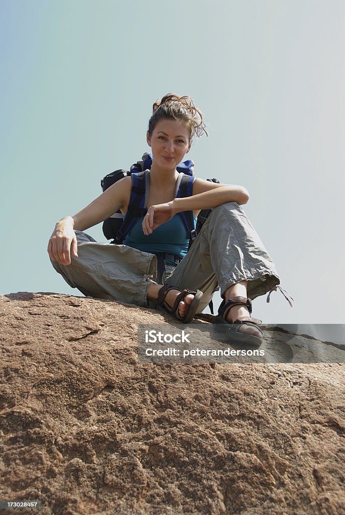 Taking a break Woman sat on top of a rock Cargo Pants Stock Photo