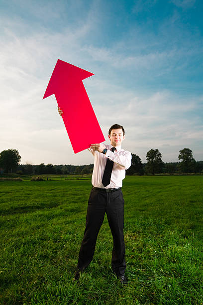 istock Young businessman with big red arrow 173028740