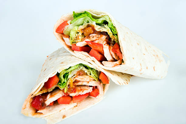 Chicken wrap cut in half on a white background stock photo