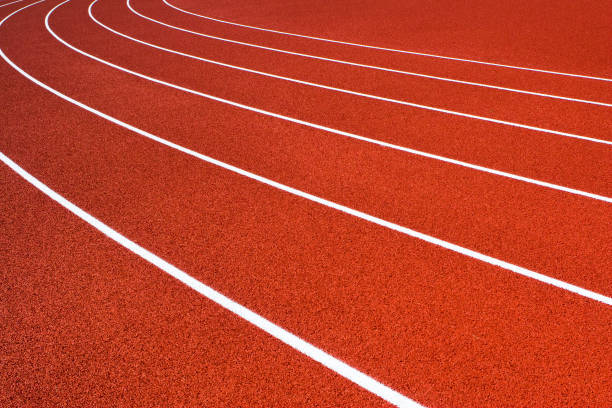 istock Red orange running track with white lane lines 173029250