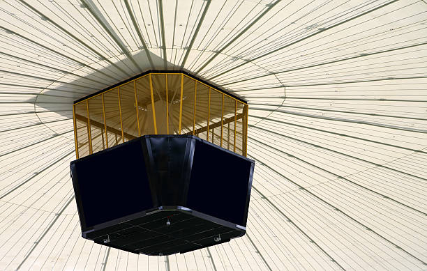 Huge video screen cube "Huge video screen cube hanging from top of modern sports dome, including copy space" giant cube stock pictures, royalty-free photos & images
