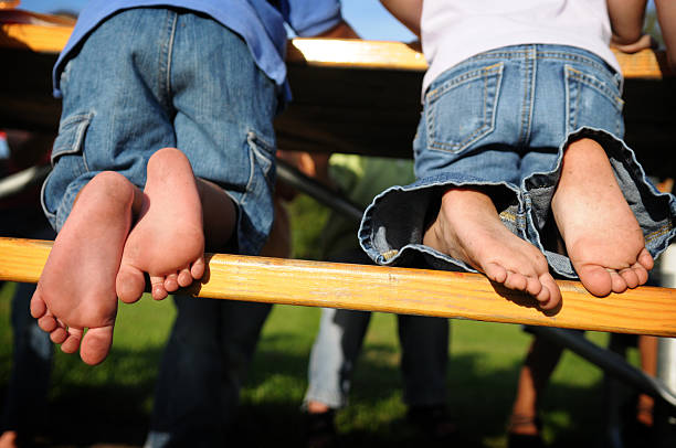 istock Two Little Kids' Bare Feet at Picnic Table 173030118
