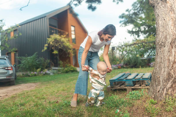 istock A babysitter helps a little baby boy learn to walk and take his first steps 1730310534