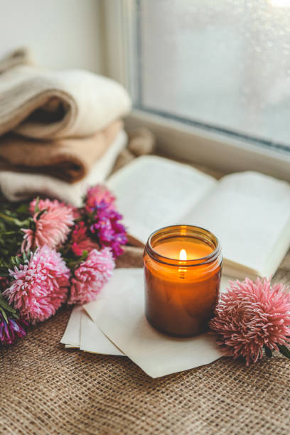 istock Burning candle, flowers, open book, cozy autumn 1730310931