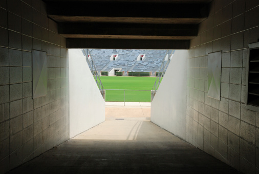 Long version of football stadium tunnel with fence.