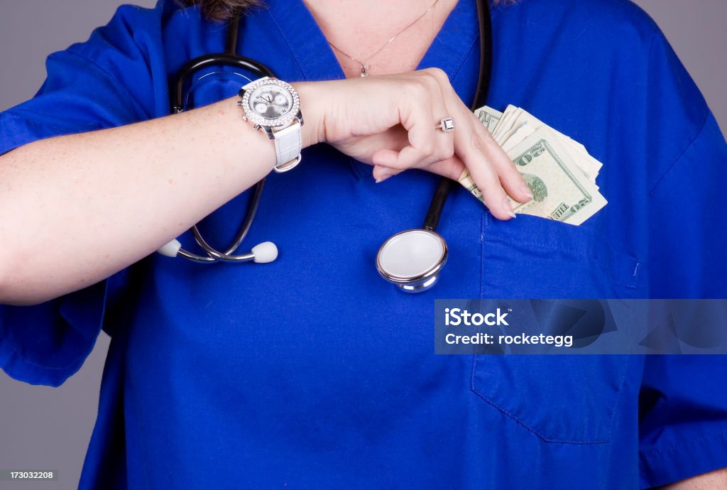 Il medico o l'infermiere del suo posizionamento soldi in tasca - Foto stock royalty-free di Infermiere