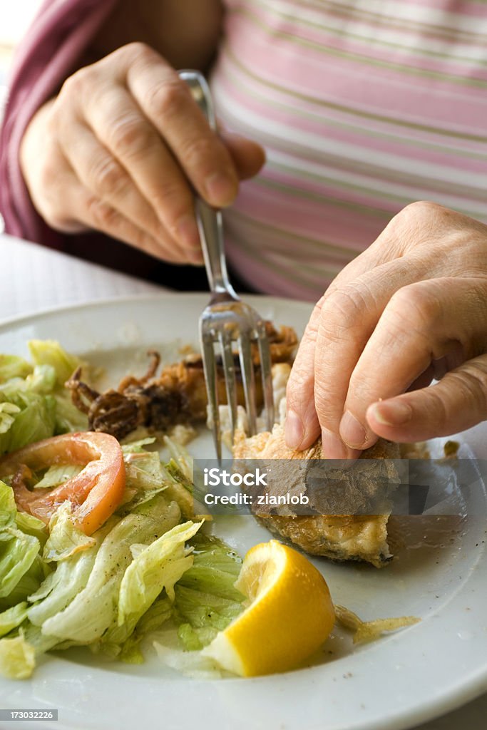 Femme âgée mangeant fishfood et pain. - Photo de Manger libre de droits