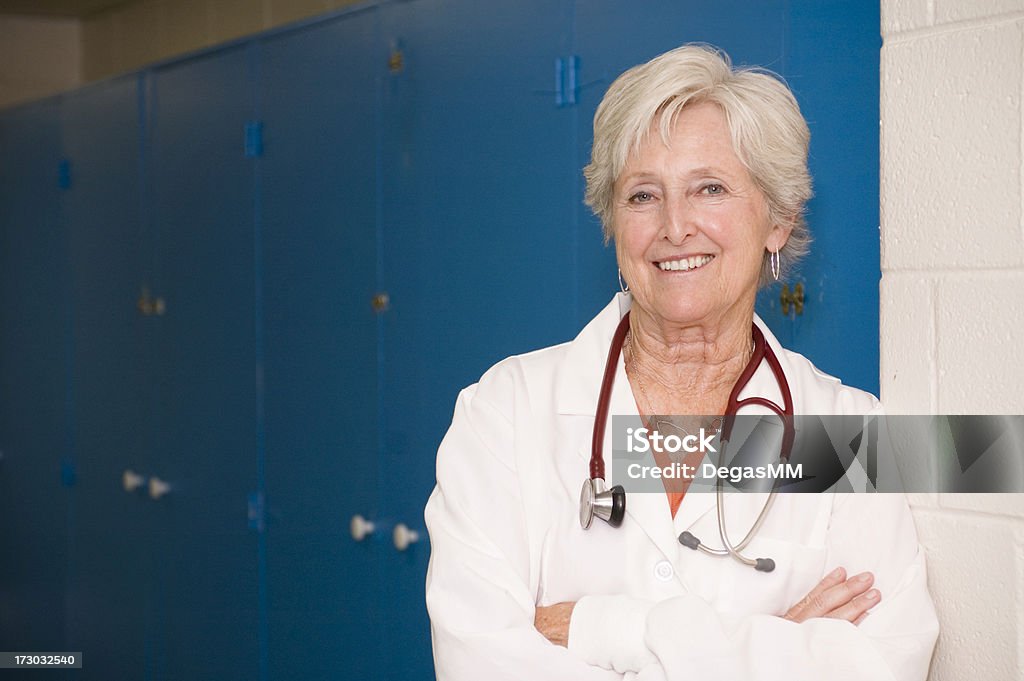Female Doctor "An attractive, friendly female doctor leans casually in the hallway." Doctor Stock Photo
